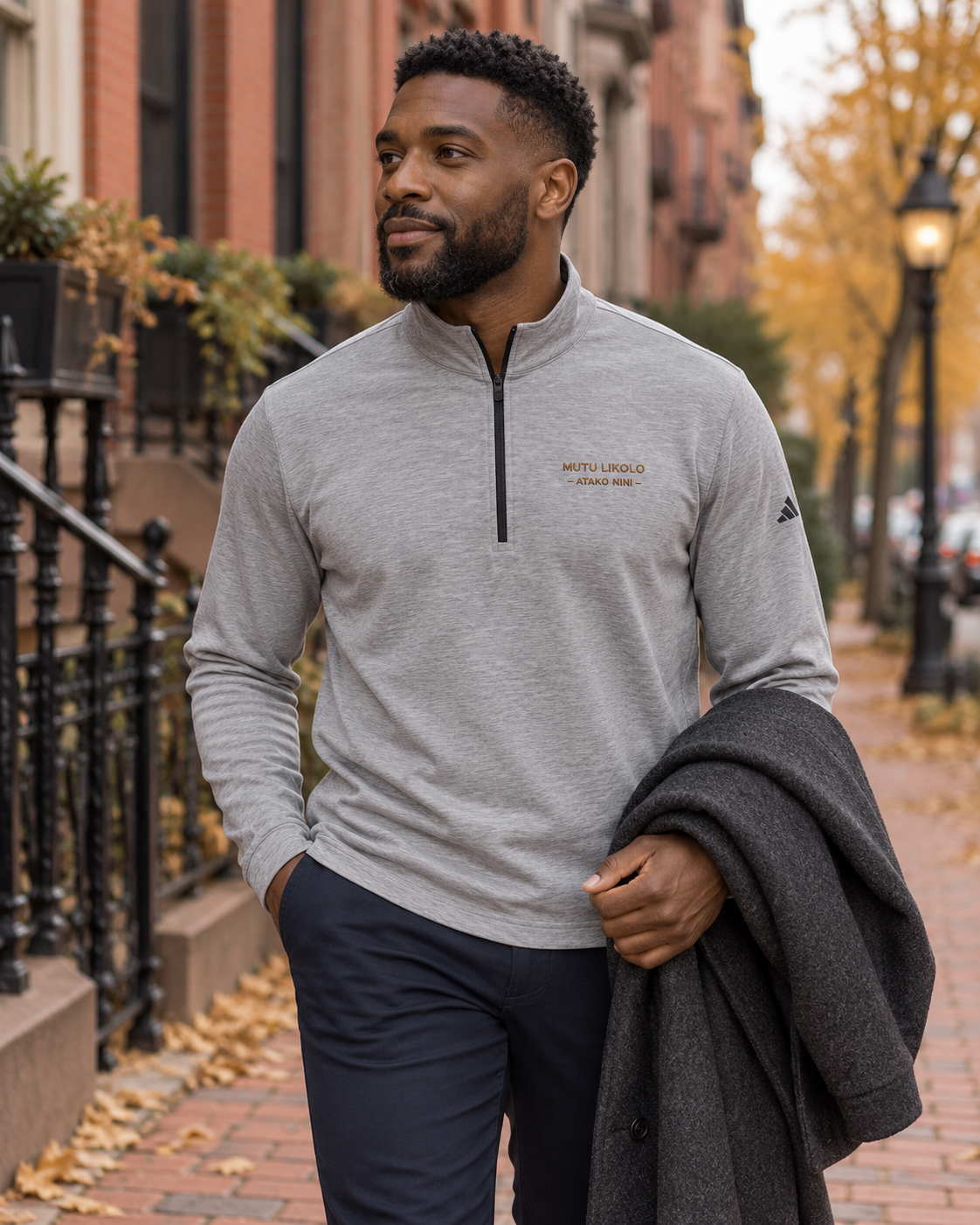 Pull à col zippé brodé Mutu Likolo gris chiné porté en ville en automne