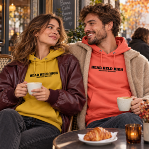 Couple portant les hoodies Bold ocre et rouge clair au café