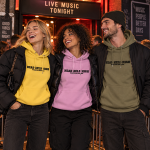 Groupe portant les hoodies Bold jaune lilas et kaki devant une salle de concert