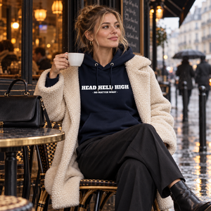 Femme portant le hoodie bio Head Held High marine au café sous la pluie