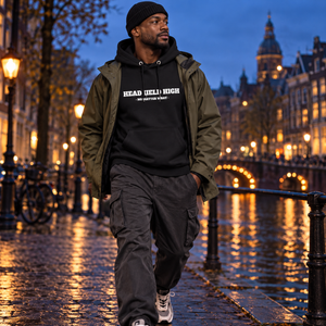 Homme portant le hoodie bio Head Held High noir avec veste technique au canal