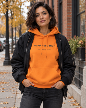 Hoodie HEAD HELD HIGH Mutu Likolo, coloris orange, porté en ville en automne-hiver — mise en scène numérique.