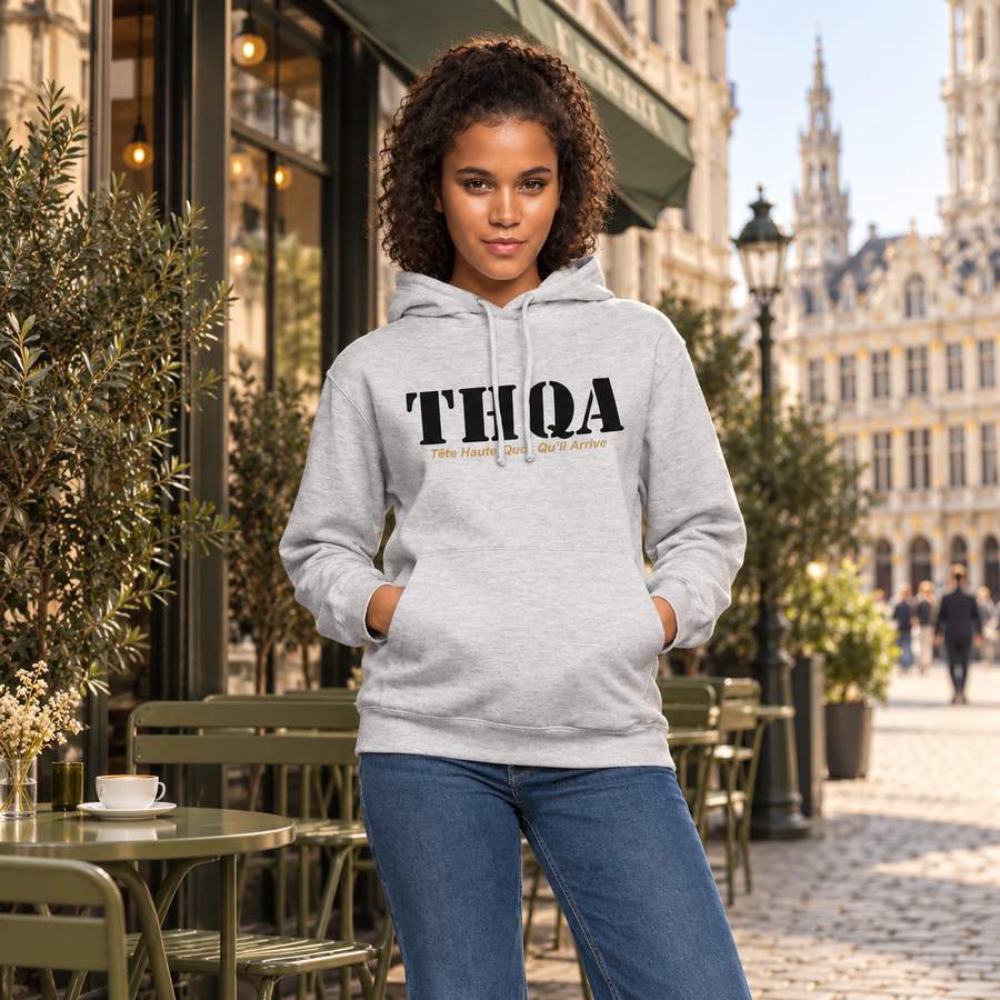 Femme portant le hoodie THQA gris chiné dans un café urbain élégant