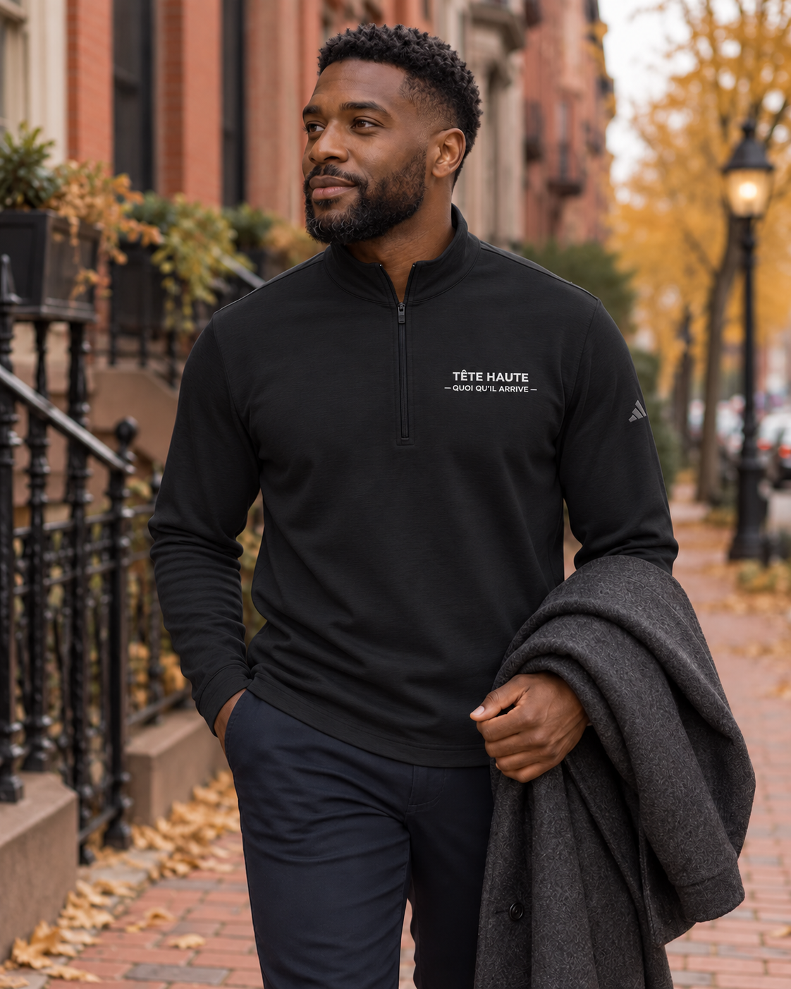 Pull TÊTE HAUTE noir, broderie blanche — mise en scène numérique urbaine.
