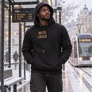 Homme portant le hoodie noir Mutu Likolo à un arrêt de tram en hiver