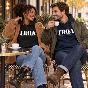 Couple portant les hoodies THQA noir et marine en terrasse