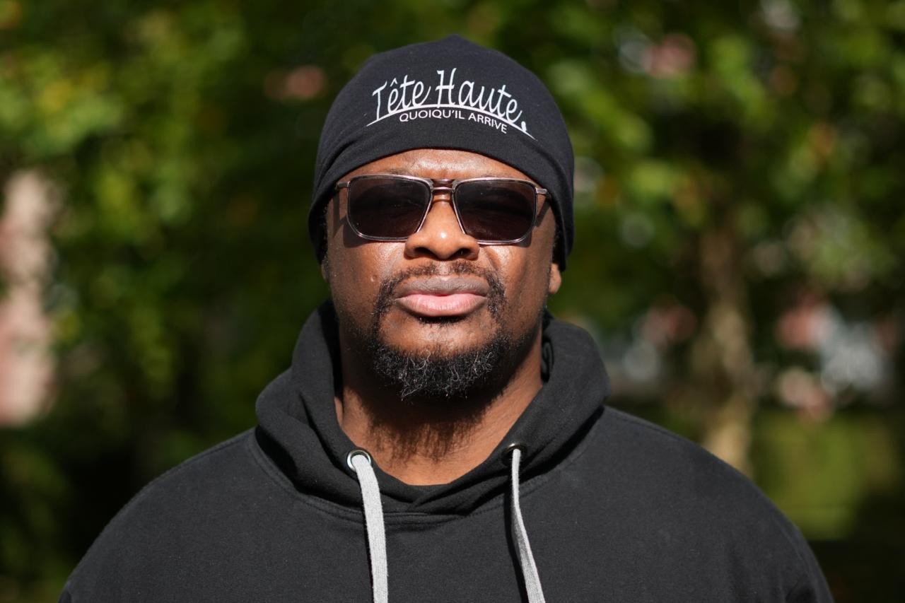 L’artiste Mutu Likolo portant un bonnet Tête haute et un hoodie noir